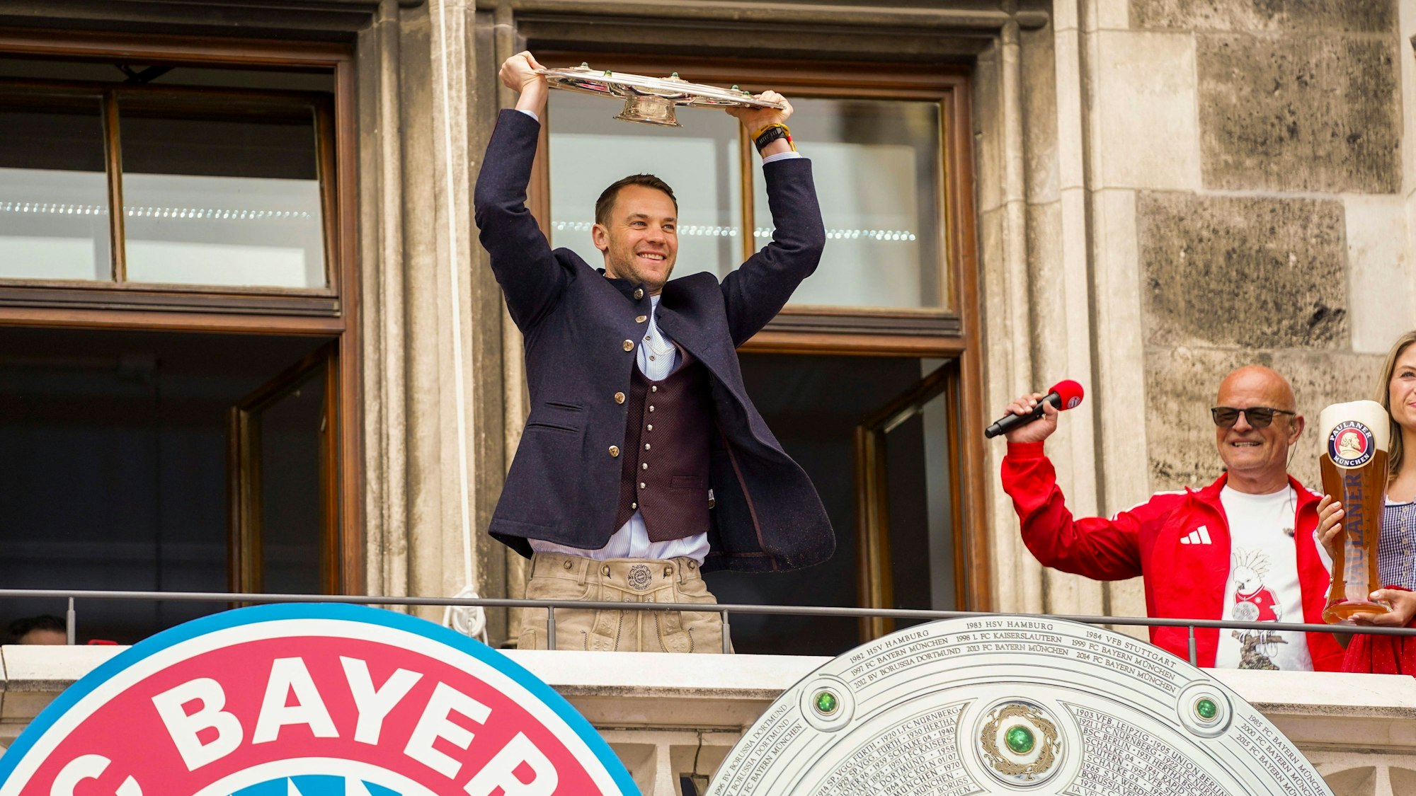 Torwart Manuel Neuer feiert auf dem Rathausbalkon in München mit der Meisterschale.