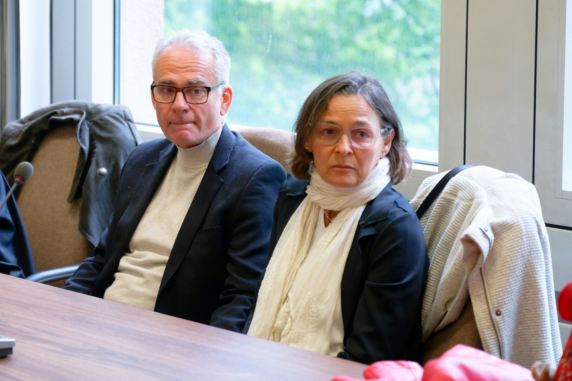 Marcus (l) und Lilian, die Eltern des getöteten Schulbegleiters, sitzen vor Prozessbeginn wegen fahrlässiger Tötung als Nebenkläger in einen Verhandlungssaal im Landgericht Köln.