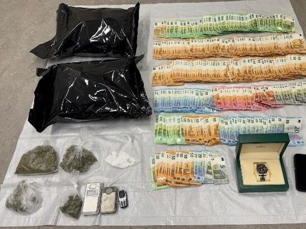 Sichergestellte Drogen, Bargeld und eine Rolex-Uhr liegen auf einem Tisch.