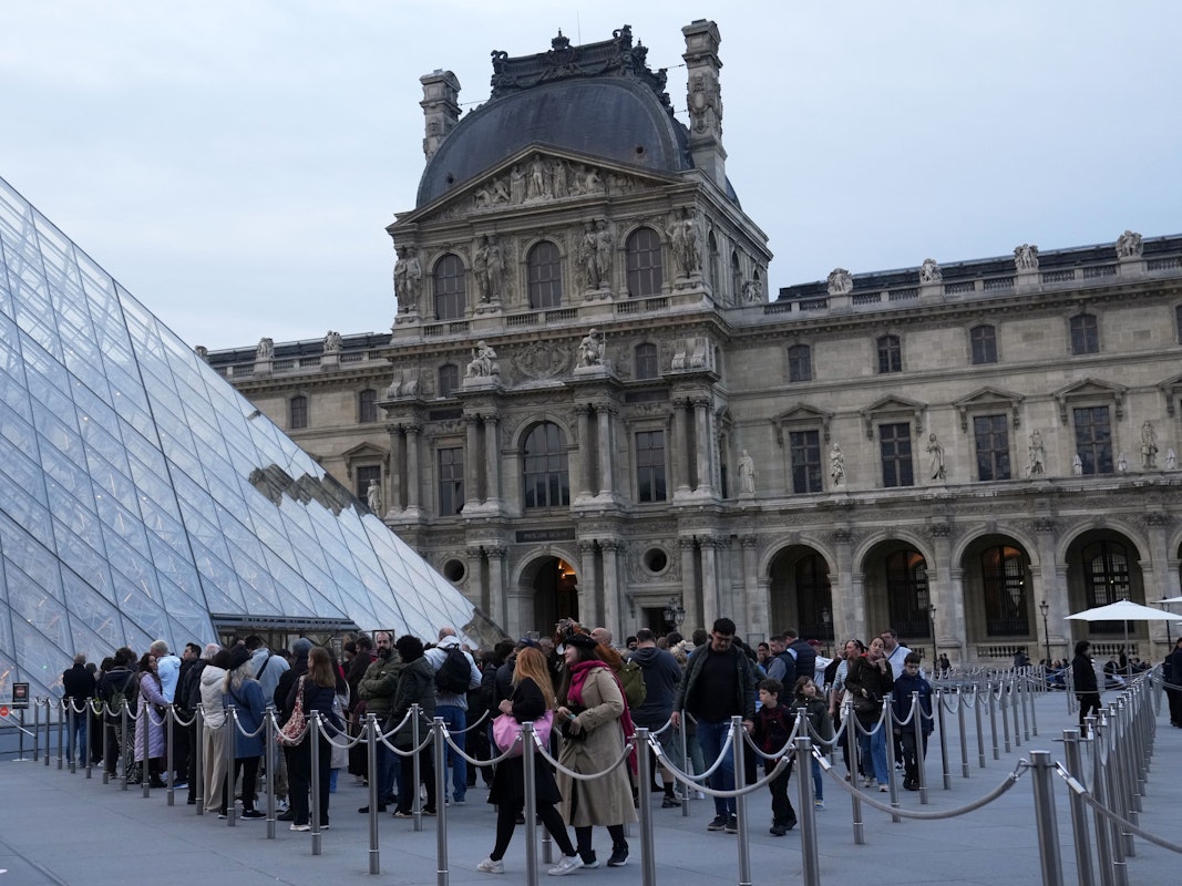 Besucher stehen Schlange, um das Louvre-Museum zu betreten.