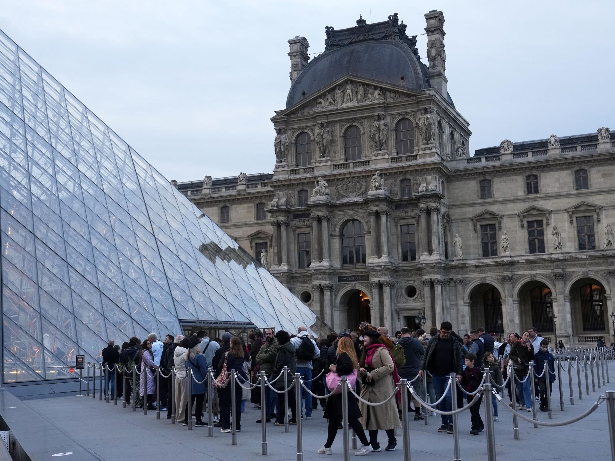 Besucher stehen Schlange, um das Louvre-Museum zu betreten.