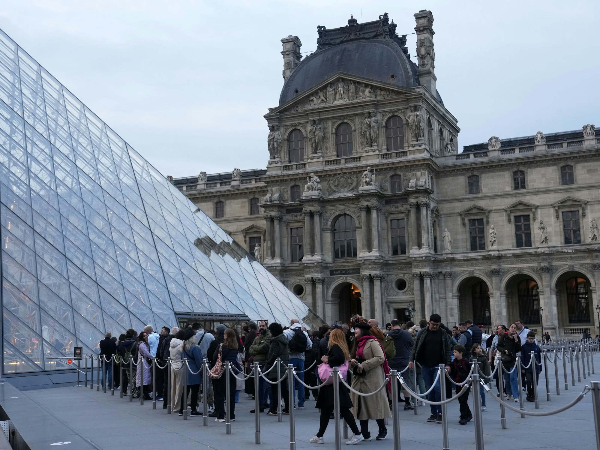 Besucher stehen Schlange, um das Louvre-Museum zu betreten.