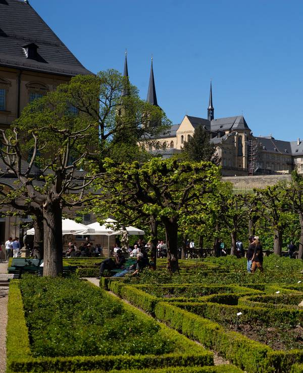 Blick auf ein Klostern, darunter ein Biergarten in einem Park