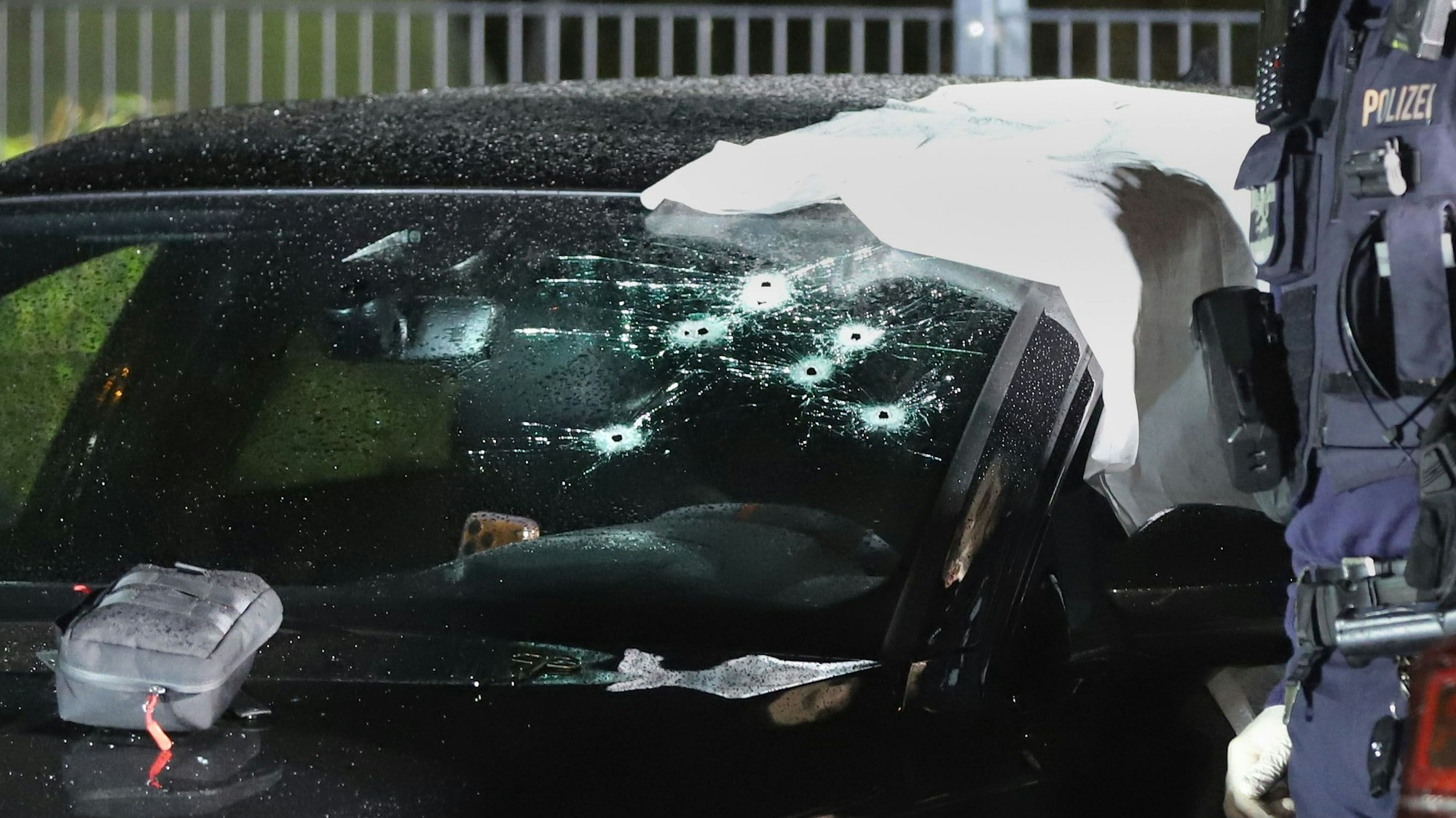 In der Windschutzscheibe eines Autos klaffen mehrere Einschusslöcher.