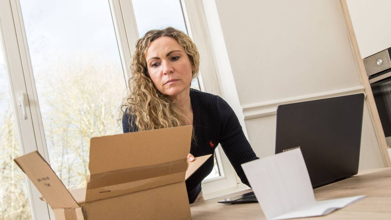 Frau schaut in den Karton einer Online-Lieferung