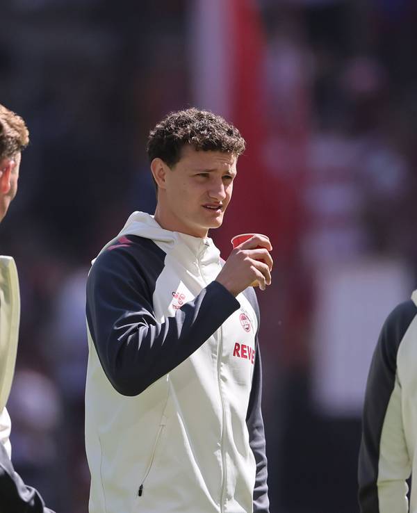 Eric Martel im Trainingsanzug mit einem Kaffee in der Hand.