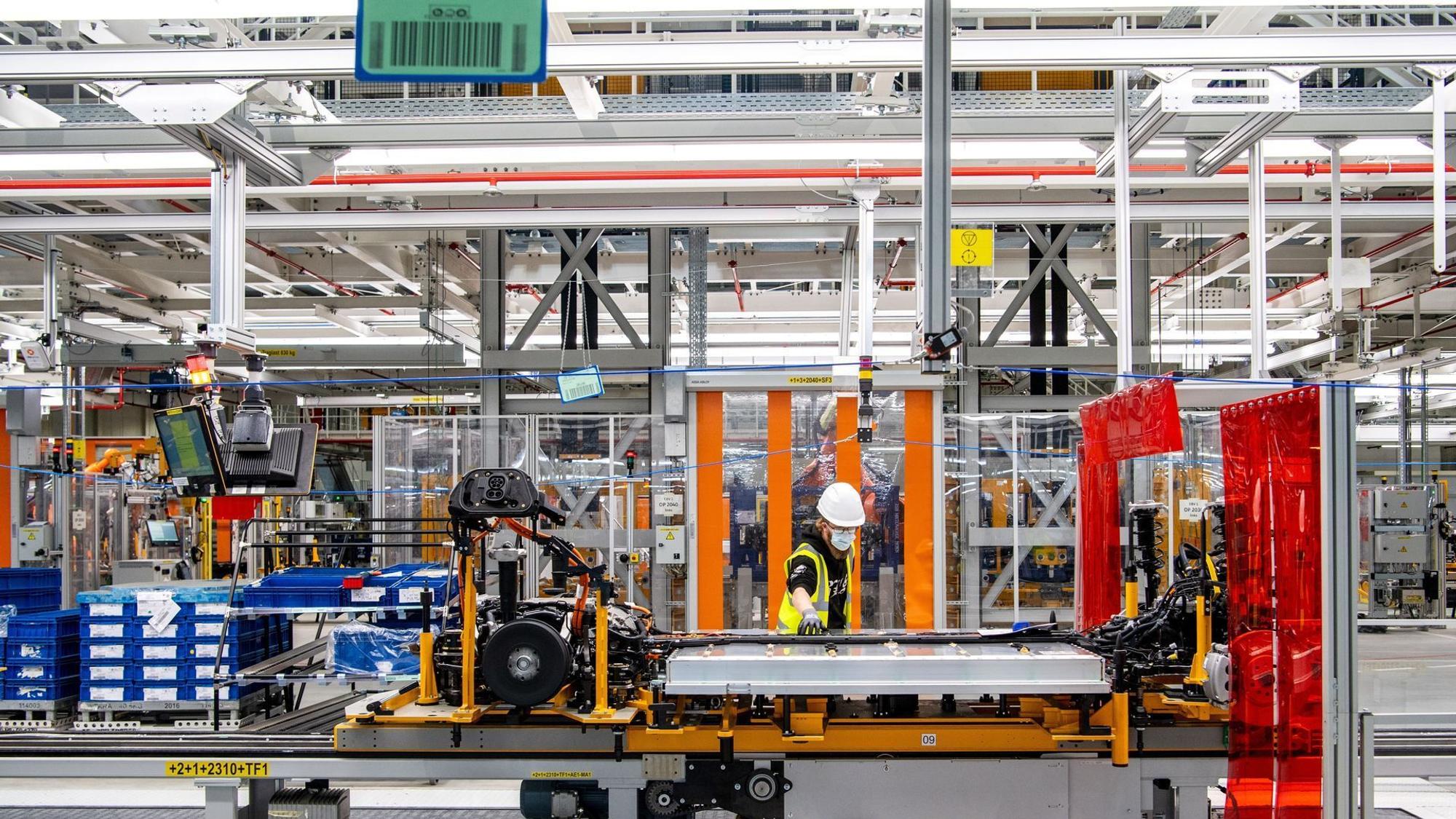 Arbeiter arbeitet mit der Batterie am Unterboden eines E-Autos