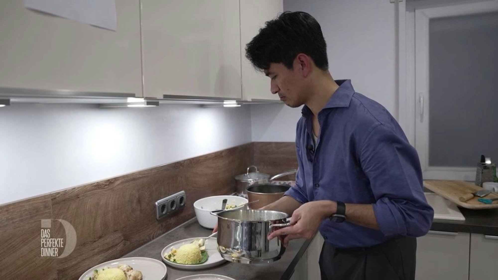 Konzentriert richtet Ragil seine Hauptspeise an: Hähnchencurry mit Ananas-Gurken-Salat und Reis.
(Bild: RTL)