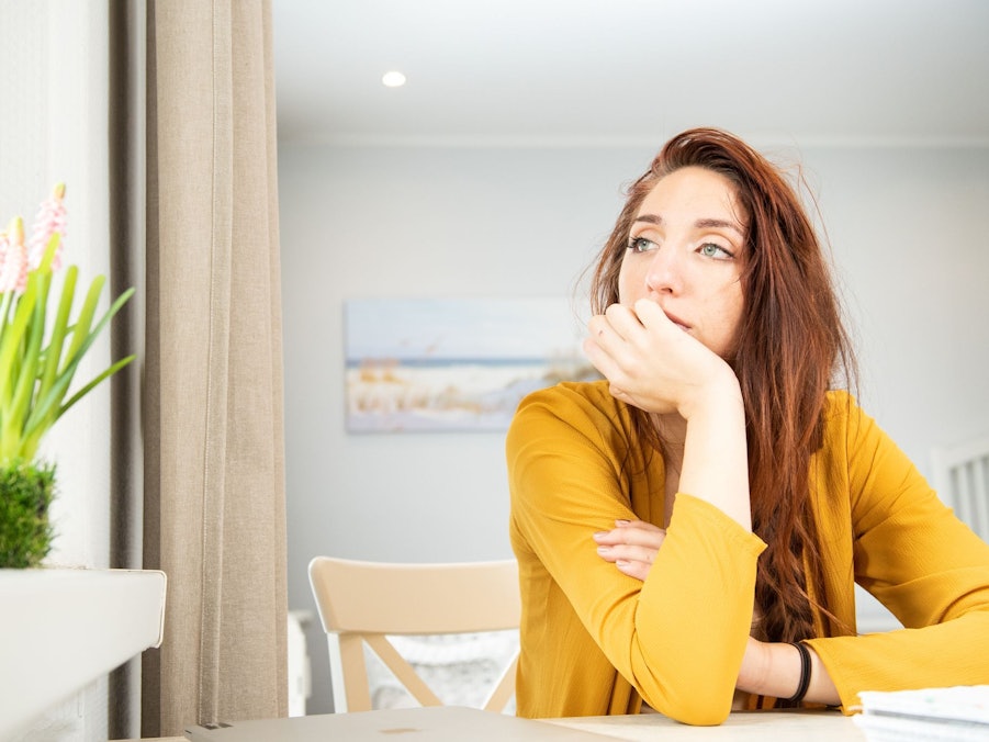 Eine junge Frau schaut aus dem Fenster