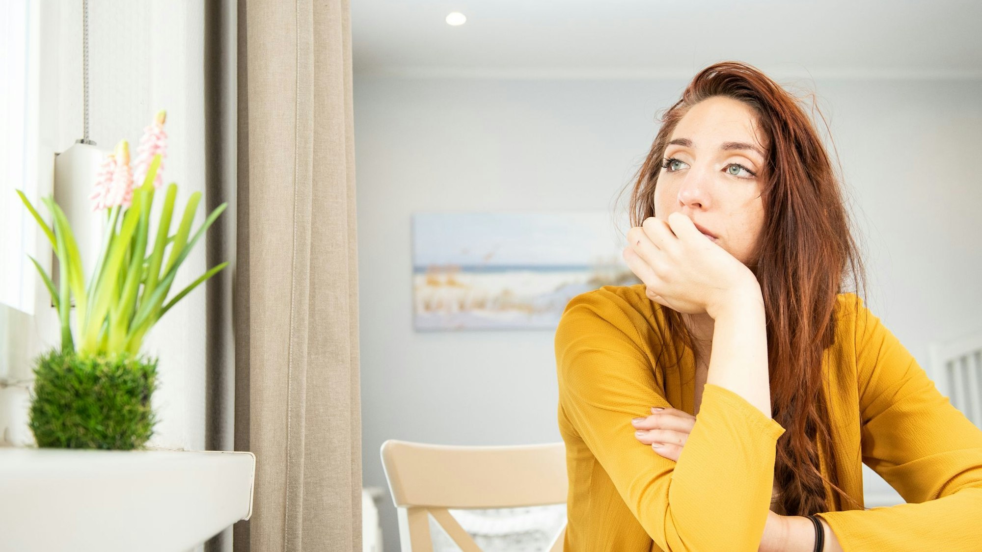 Eine junge Frau schaut aus dem Fenster