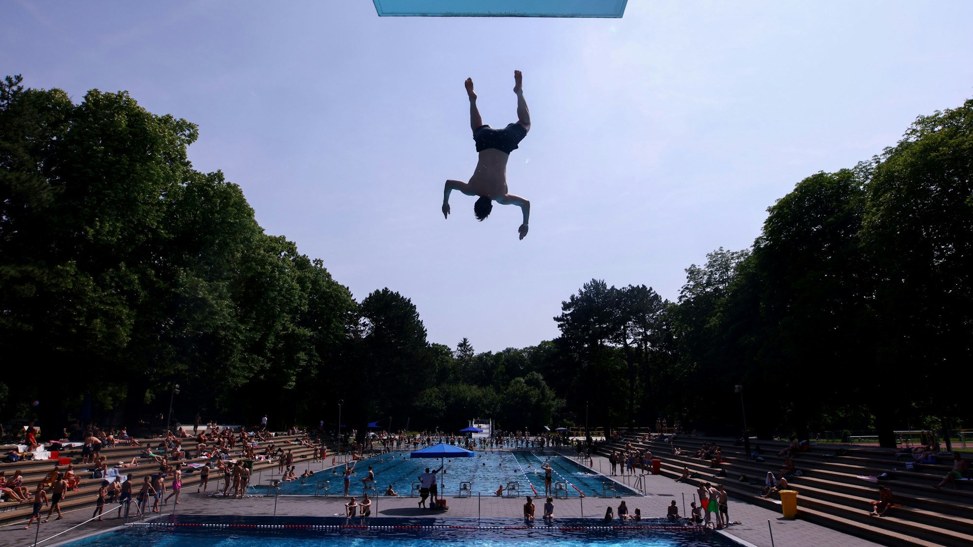 Ein junger Mann springt im Kölner Stadionbad vom 10-Meter-Turm.