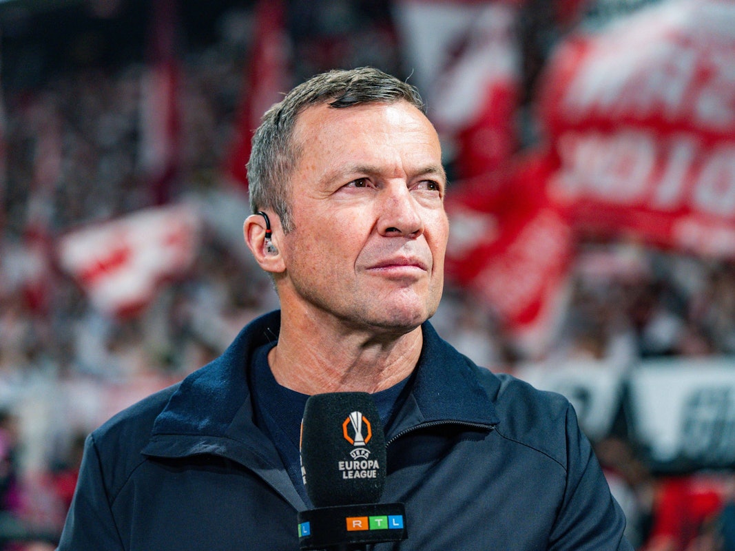 TV-Experte Lothar Matthäus hält ein Mikrofon in der Hand.