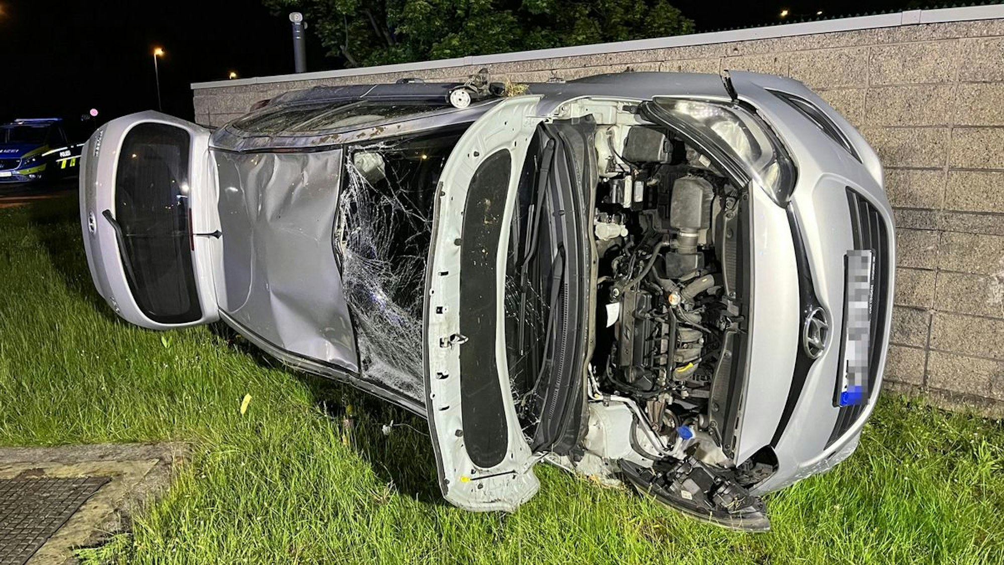 Ein auf der Seite liegendes, verunfalltes Auto in Monheim am Rhein.
