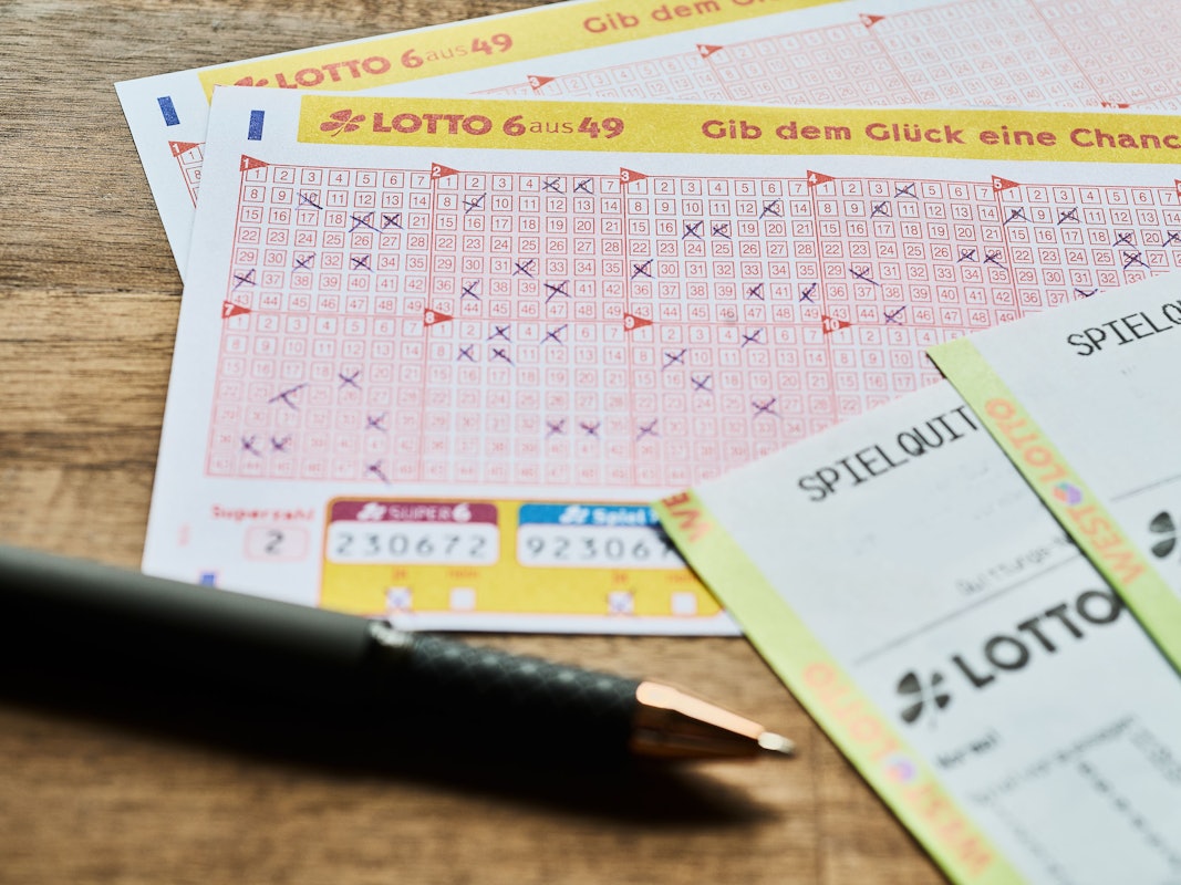 Auf einem Tisch liegt ein LOTTO 6aus49 Tippschein sowie die Spielquittung.