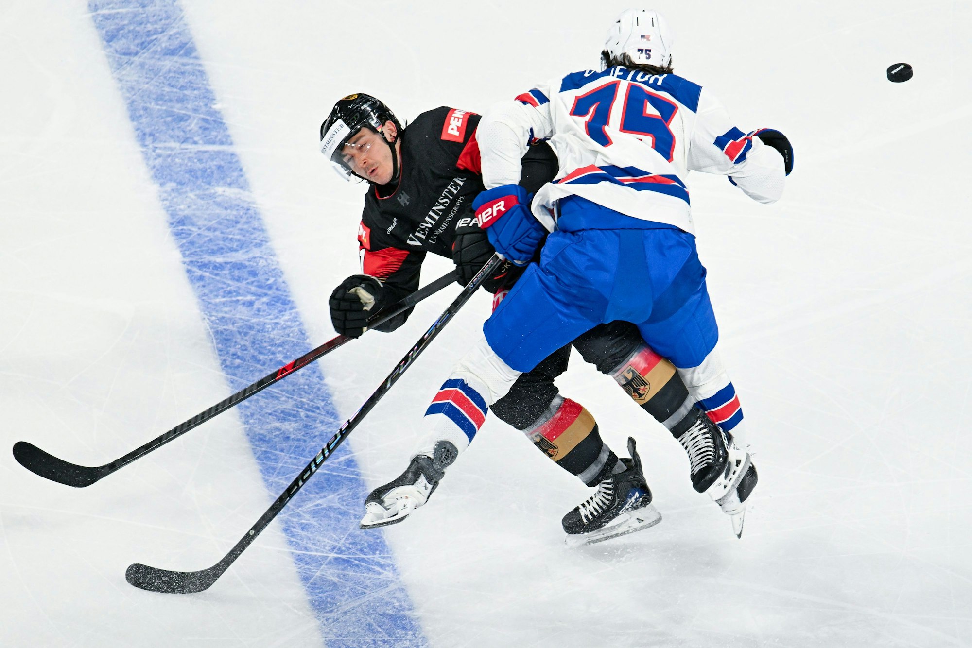Daniel Fischbuch (l, Deutschland) und Connor Clifton (USA) kämpfen um den Puck.