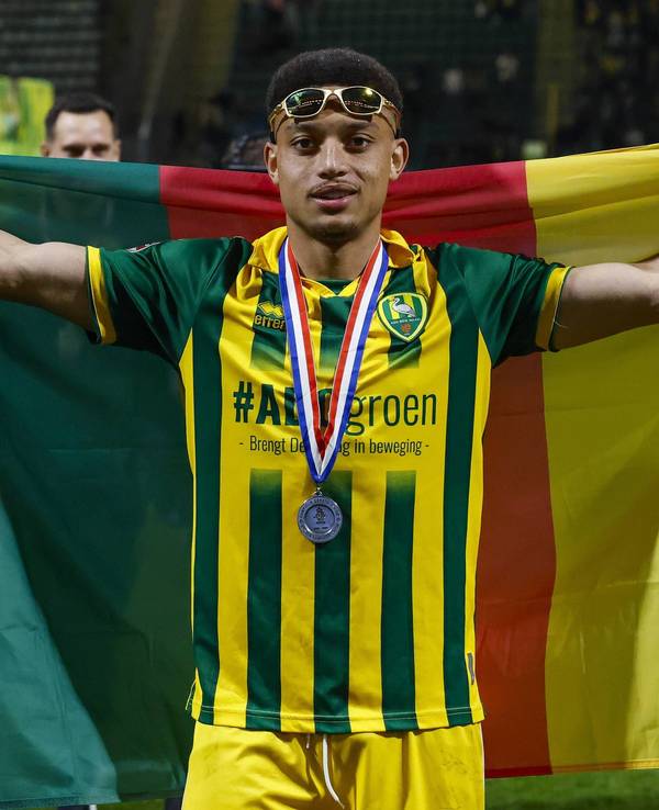 Steven van der Sloot breitet eine Kamerun-Flagge hinter sich aus.