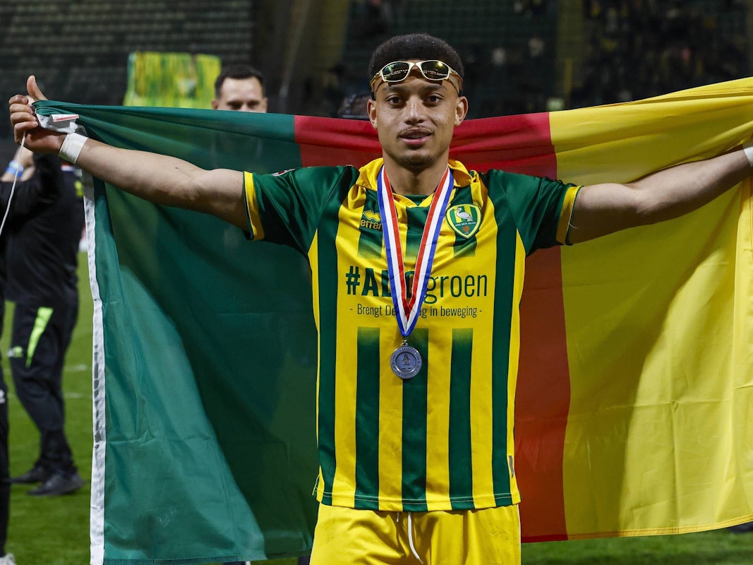 Steven van der Sloot breitet eine Kamerun-Flagge hinter sich aus.