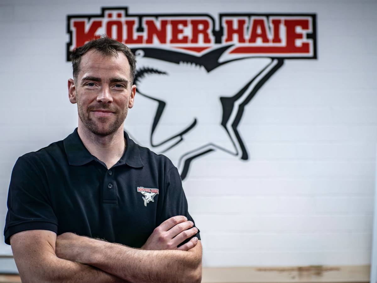 Marcel Noebels posiert vor dem Logo der Kölner Haie.