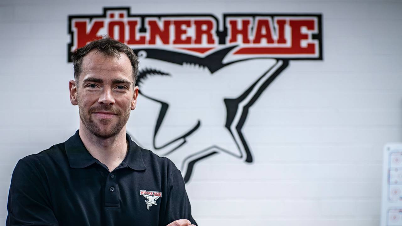 Marcel Noebels posiert vor dem Logo der Kölner Haie.