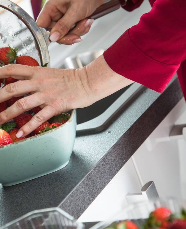 Frau wäscht Erdbeeren