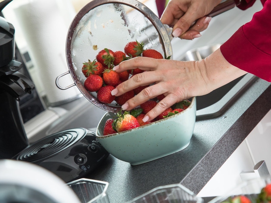 Frau wäscht Erdbeeren