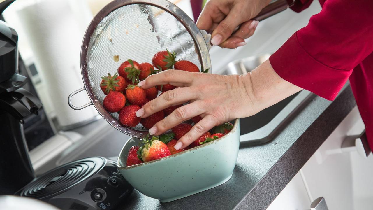 Frau wäscht Erdbeeren