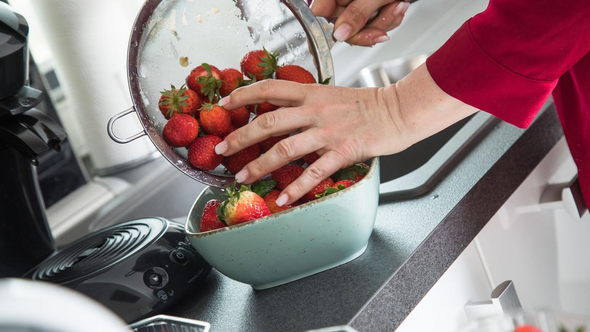 Frau wäscht Erdbeeren