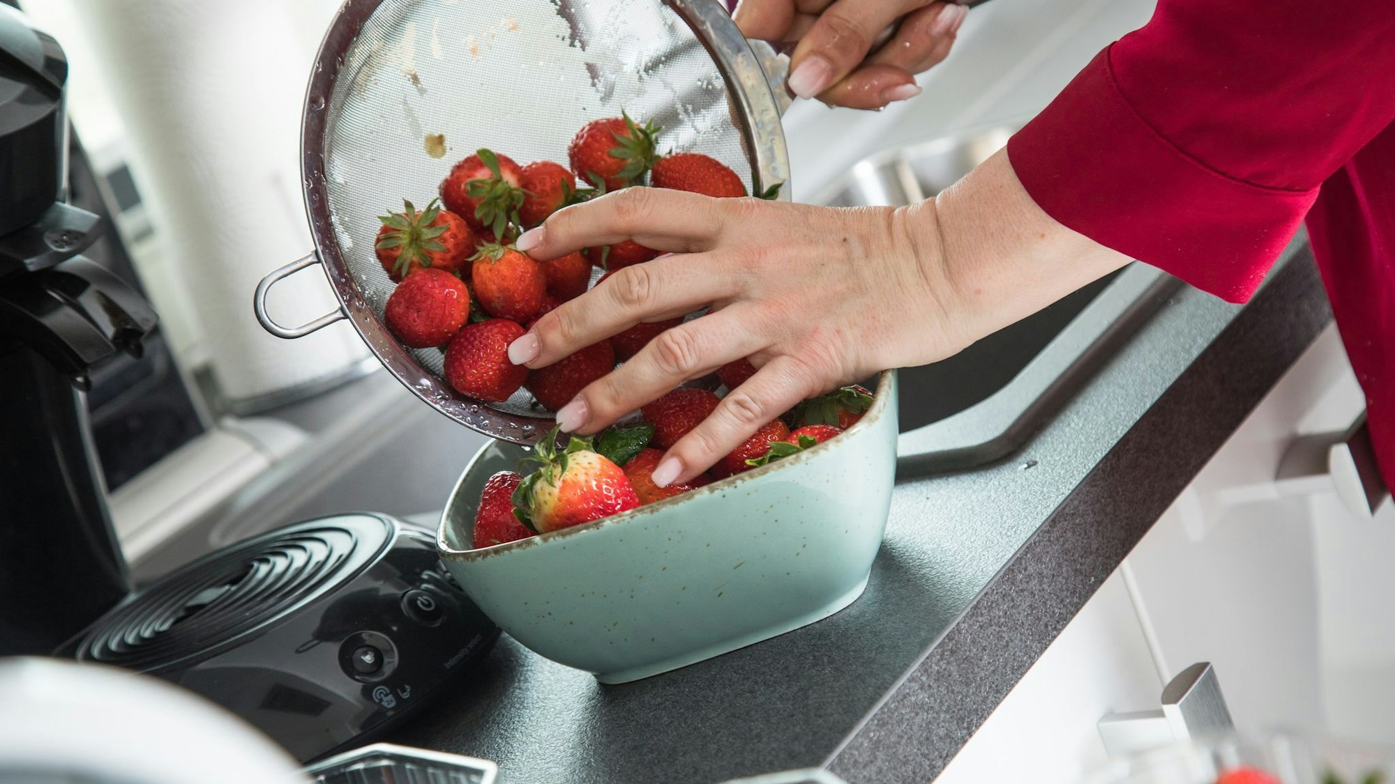 Frau wäscht Erdbeeren