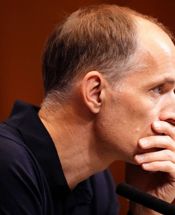 Thomas Tuchel hält sich bei einer Pressekonferenz nachdenklich die Hand vor den Mund.