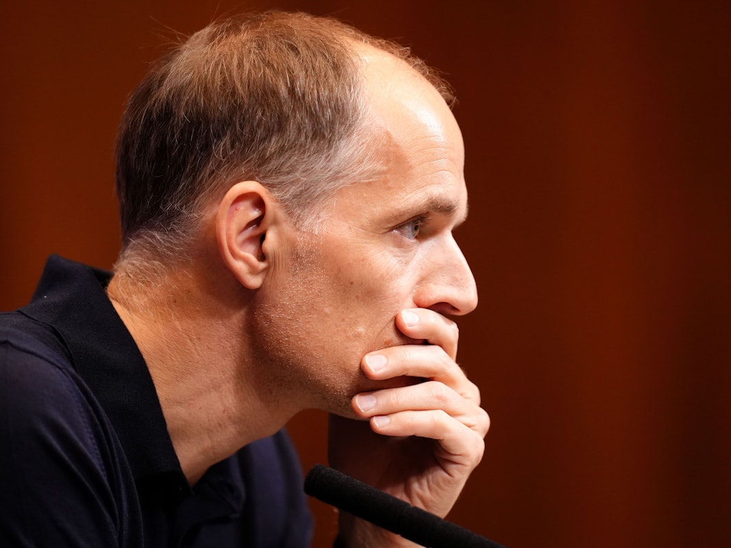 Thomas Tuchel hält sich bei einer Pressekonferenz nachdenklich die Hand vor den Mund.