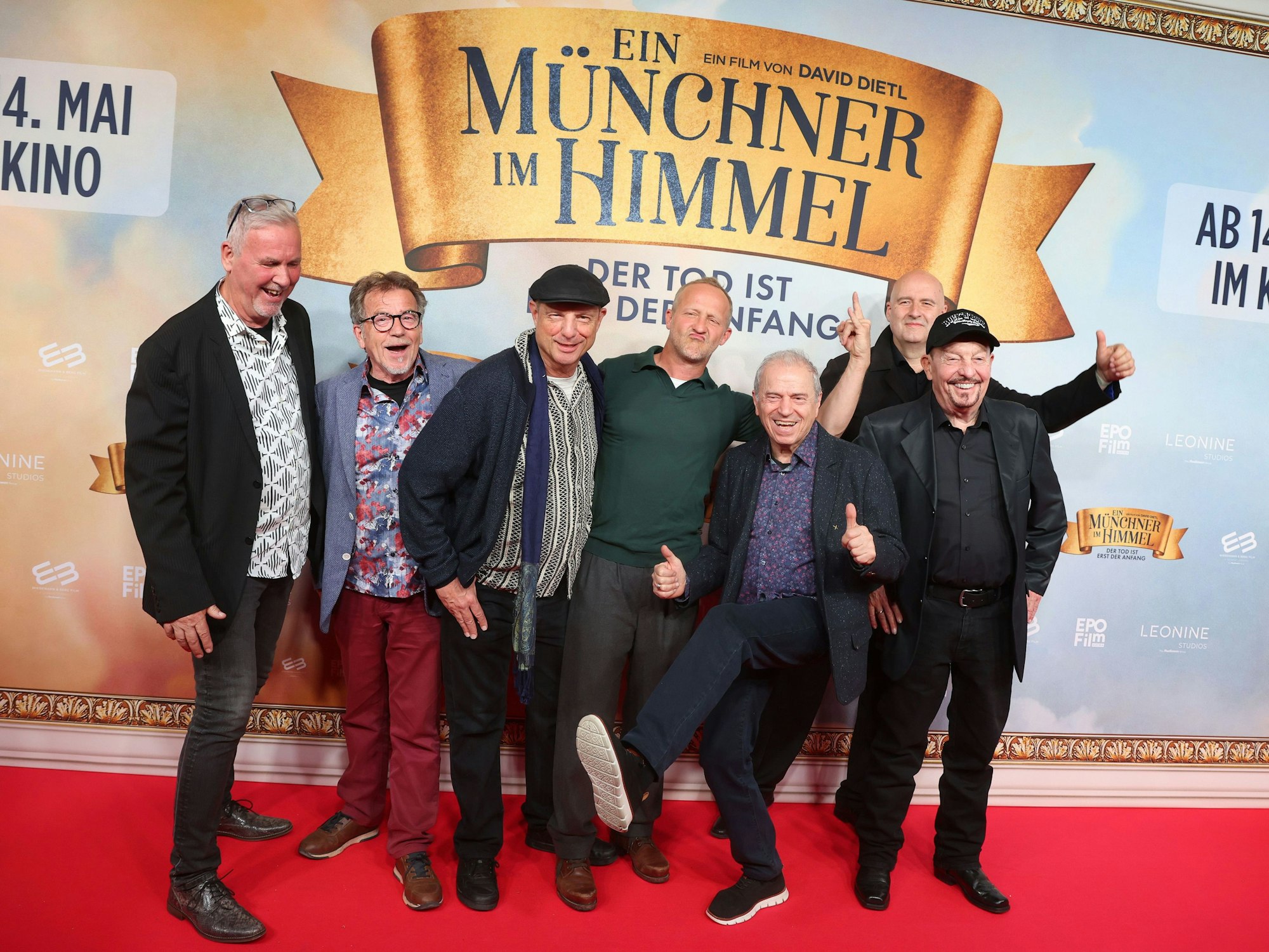 Mitglieder der „Spider Murphy Gang“ stehen mit Schauspieler Maximilian Brückner (M) vor der Premiere der Komödie „Ein Münchner im Himmel - Der Tod ist erst der Anfang“ im Mathäser Filmpalast auf dem roten Teppich.