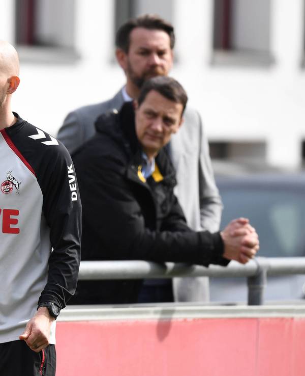 Trainer René Wagner steht auf dem Trainingsplatz, die FC-Bosse Thoma Kessler und Ulf Sobek schauen ihm kritisch zu.