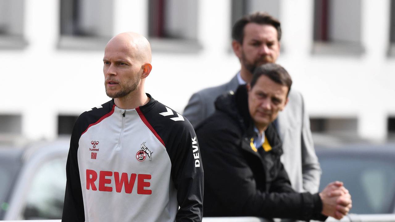 Trainer René Wagner steht auf dem Trainingsplatz, die FC-Bosse Thoma Kessler und Ulf Sobek schauen ihm kritisch zu.
