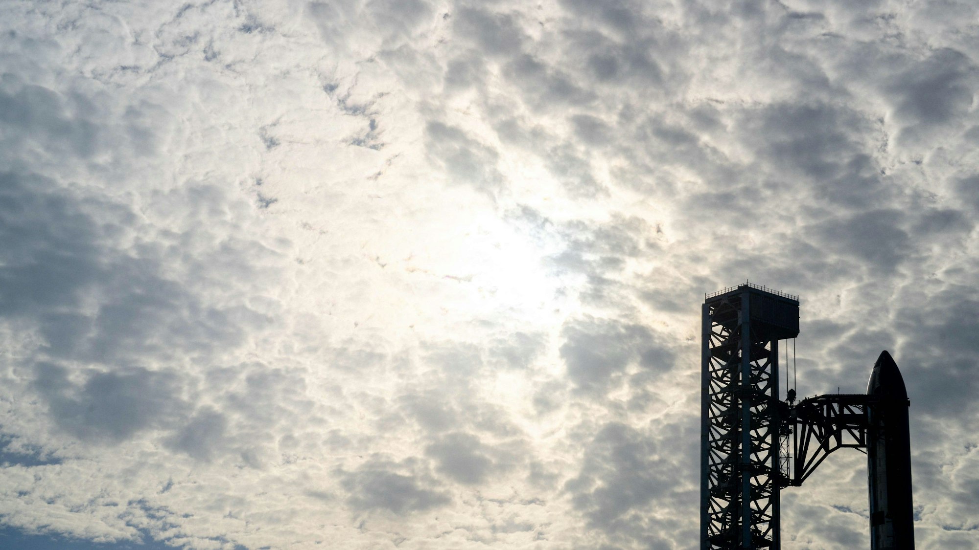 Elon Musk's Rakete und Startturm unter Wolken