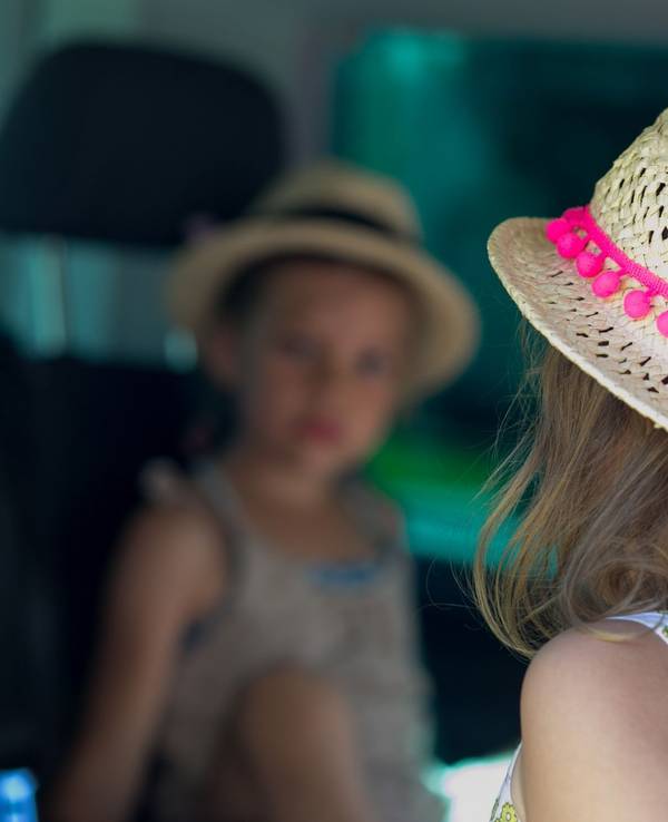 Zwei Kinder in Sommerkleidung sitzen im Auto