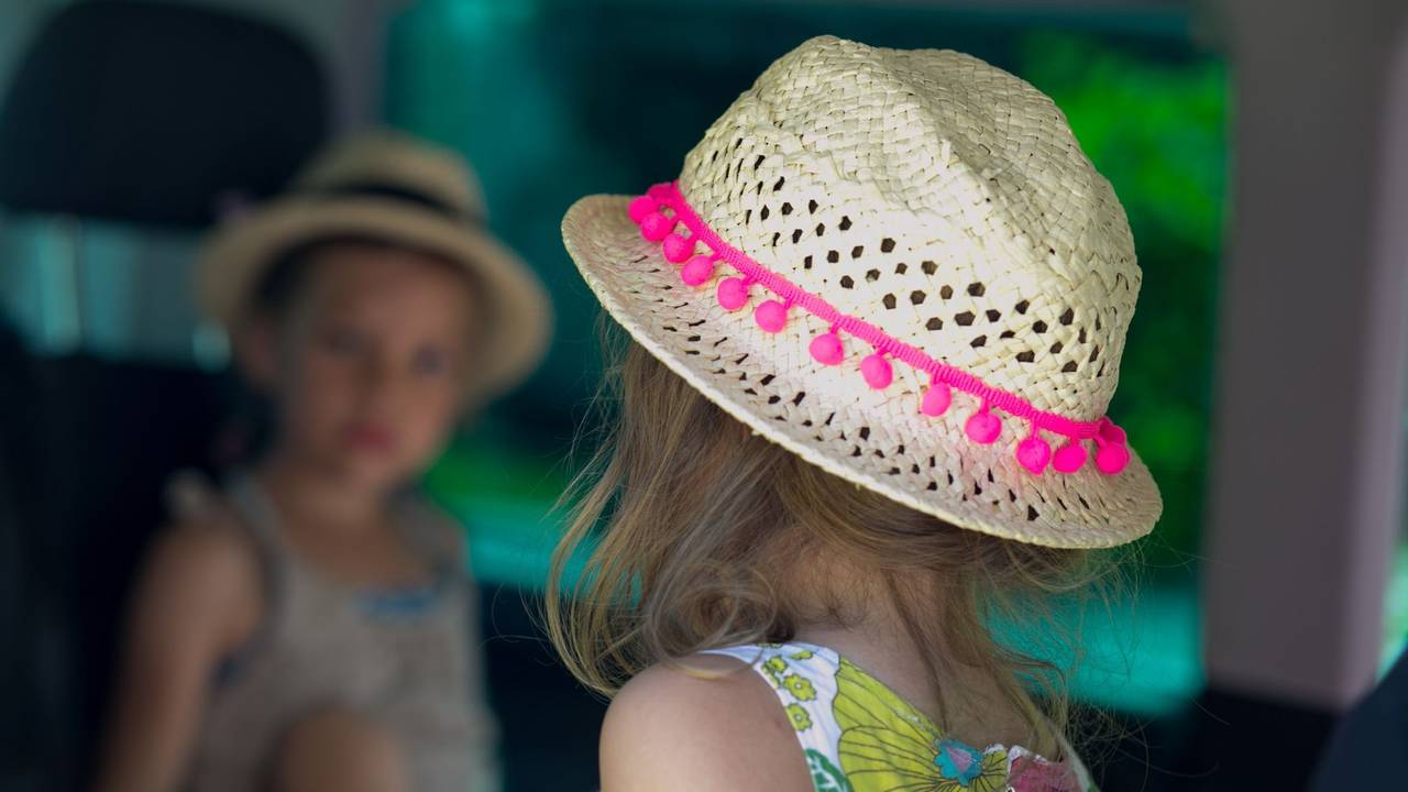 Zwei Kinder in Sommerkleidung sitzen im Auto