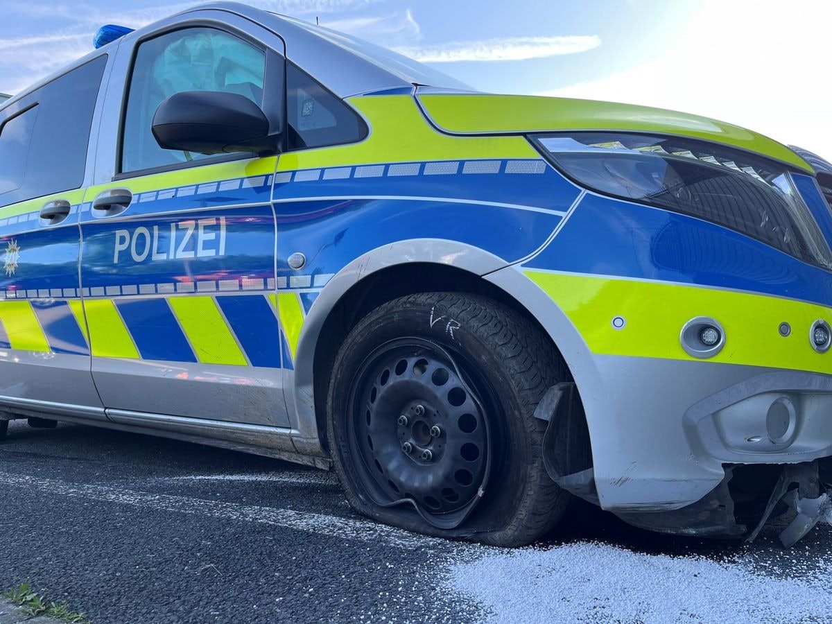 Ein beschädigter Streifenwagen der Polizei steht am Straßenrand.