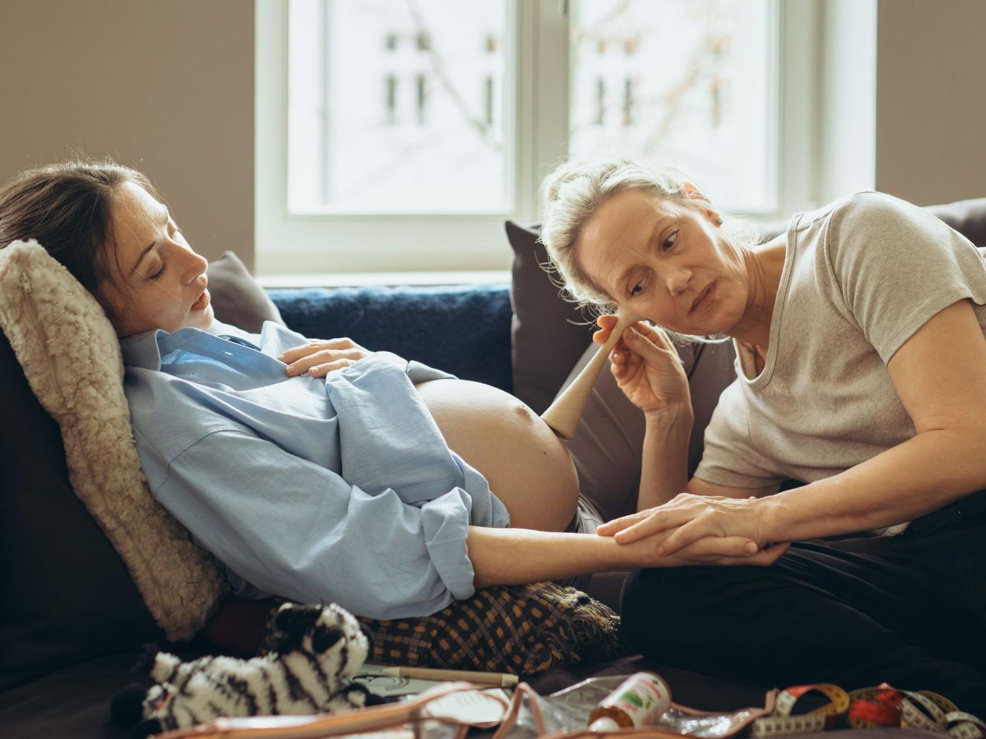 Eine Hebamme horcht mit einem Instrument nach den Herztönen eines Babys