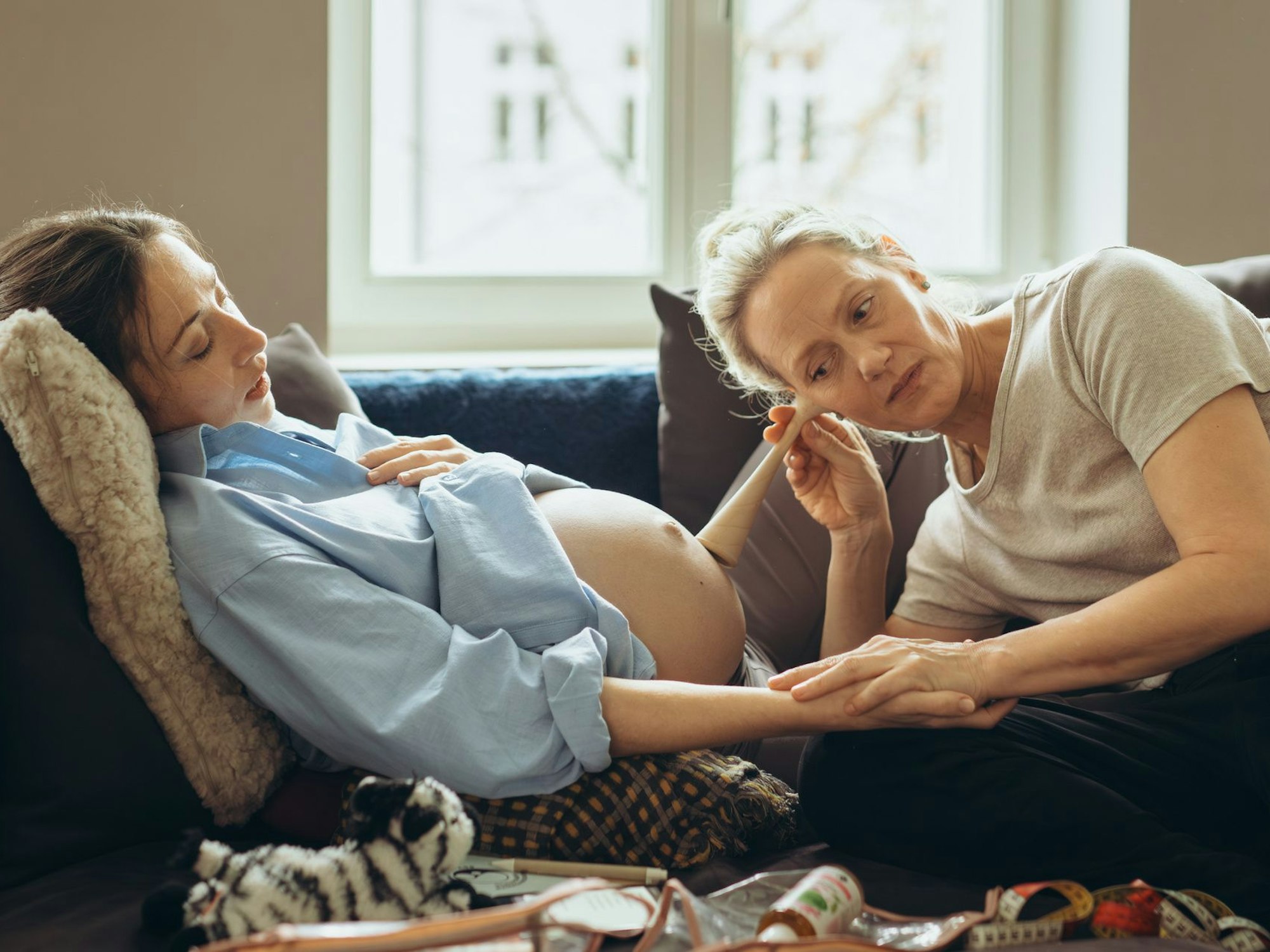 Eine Hebamme horcht mit einem Instrument nach den Herztönen eines Babys