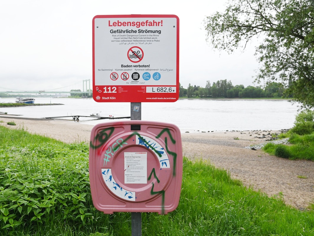 Auch am Kölner Rheinufer stehen neue Schilder, die auf das Badeverbot im Rhein hinweisen.