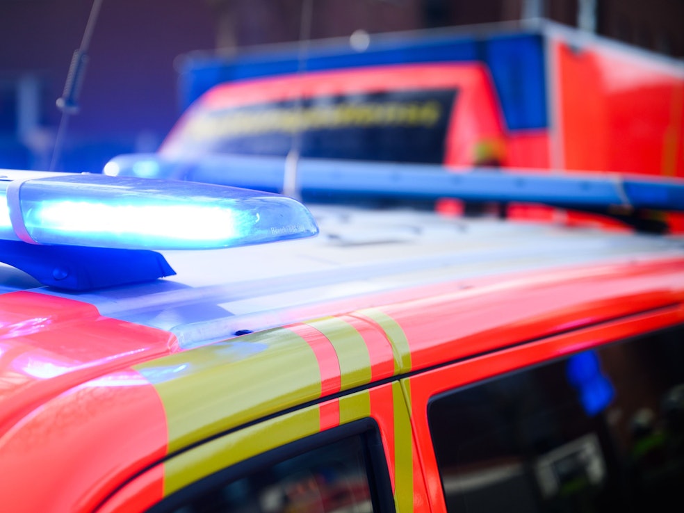 Blaulichter leuchten an einer Einsatzstelle auf einem Notarzt Fahrzeug und einem Rettungswagen.