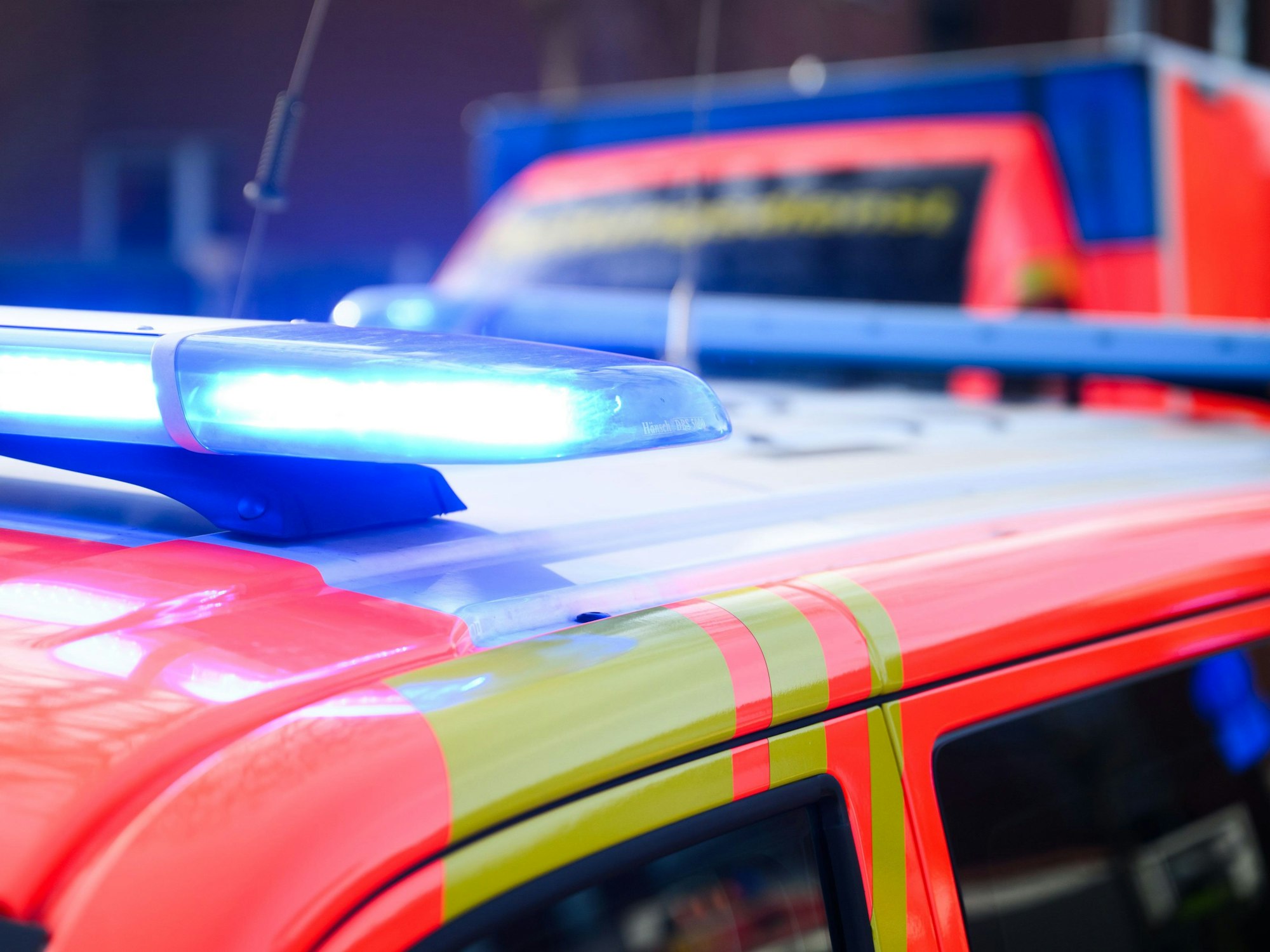 Blaulichter leuchten an einer Einsatzstelle auf einem Notarzt Fahrzeug und einem Rettungswagen.