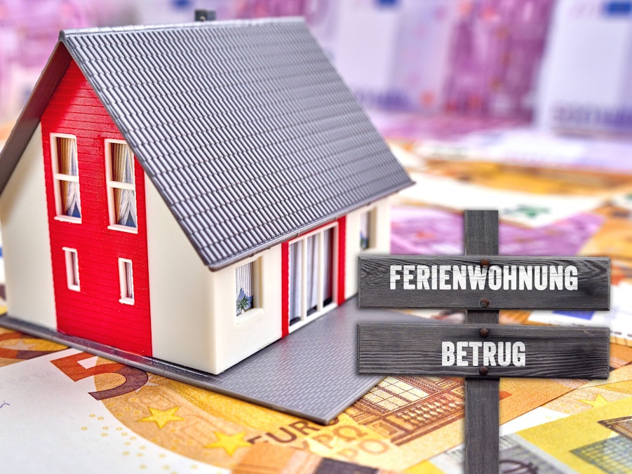 Wohngebäude, Banknoten und Schild mit Ferienwohnung Betrug