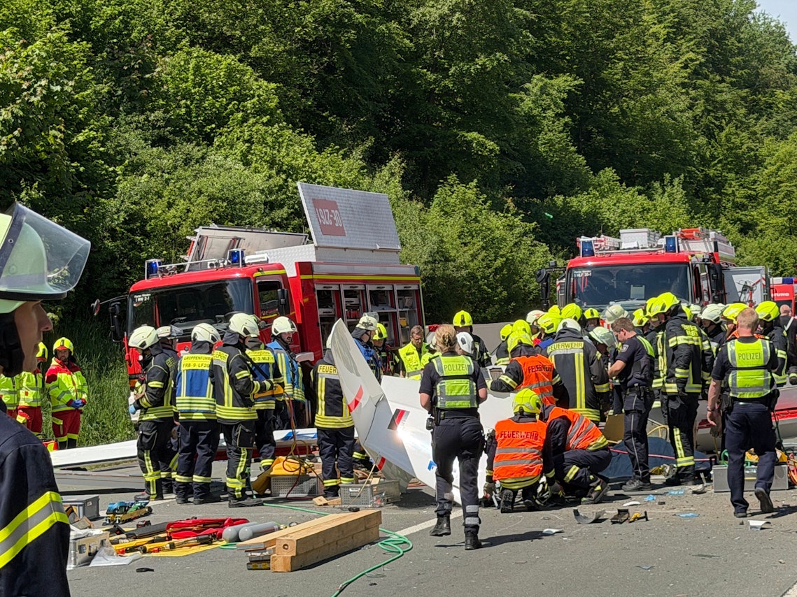 Rettungsdienste und Polizei arbeiten an der Unfallstelle, nachdem ein Segelflugzeug auf die A45 gestürzt ist. Dabei ist nach Auskunft der Polizei ein Mensch ums Leben gekommen.