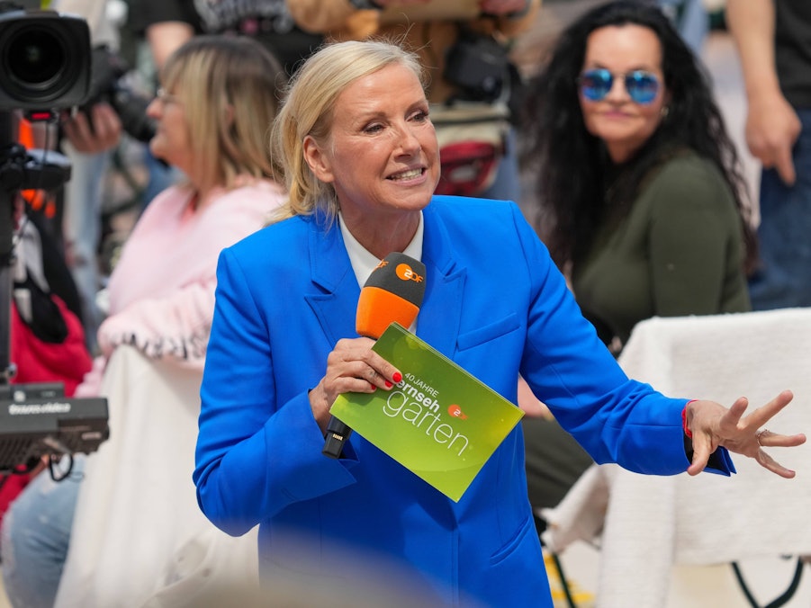 Andrea Kiewel mit Mikrofon und Unterlagen