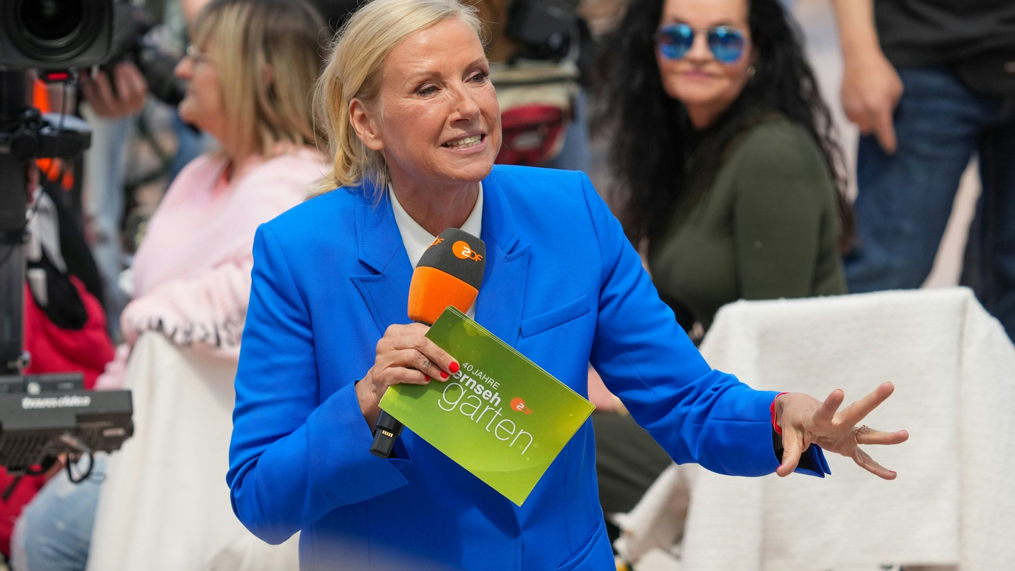 Andrea Kiewel mit Mikrofon und Unterlagen