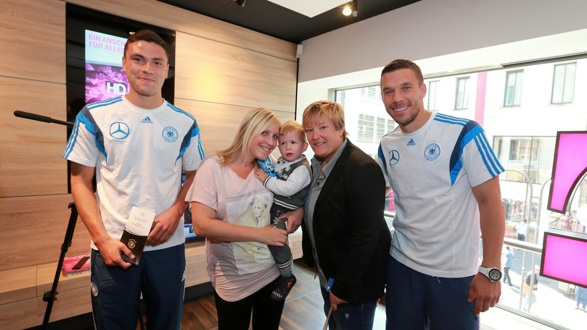 Sarah Reuter mit Lukas Podolski und Jonas Hector.