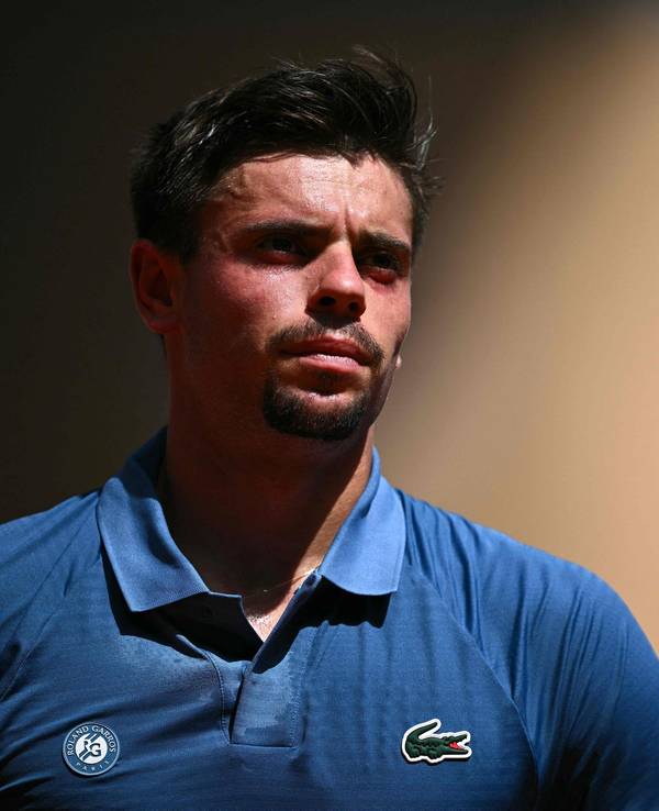 Arthur Géa trägt bei einem Tennis-Match ein blaues Poloshirt.