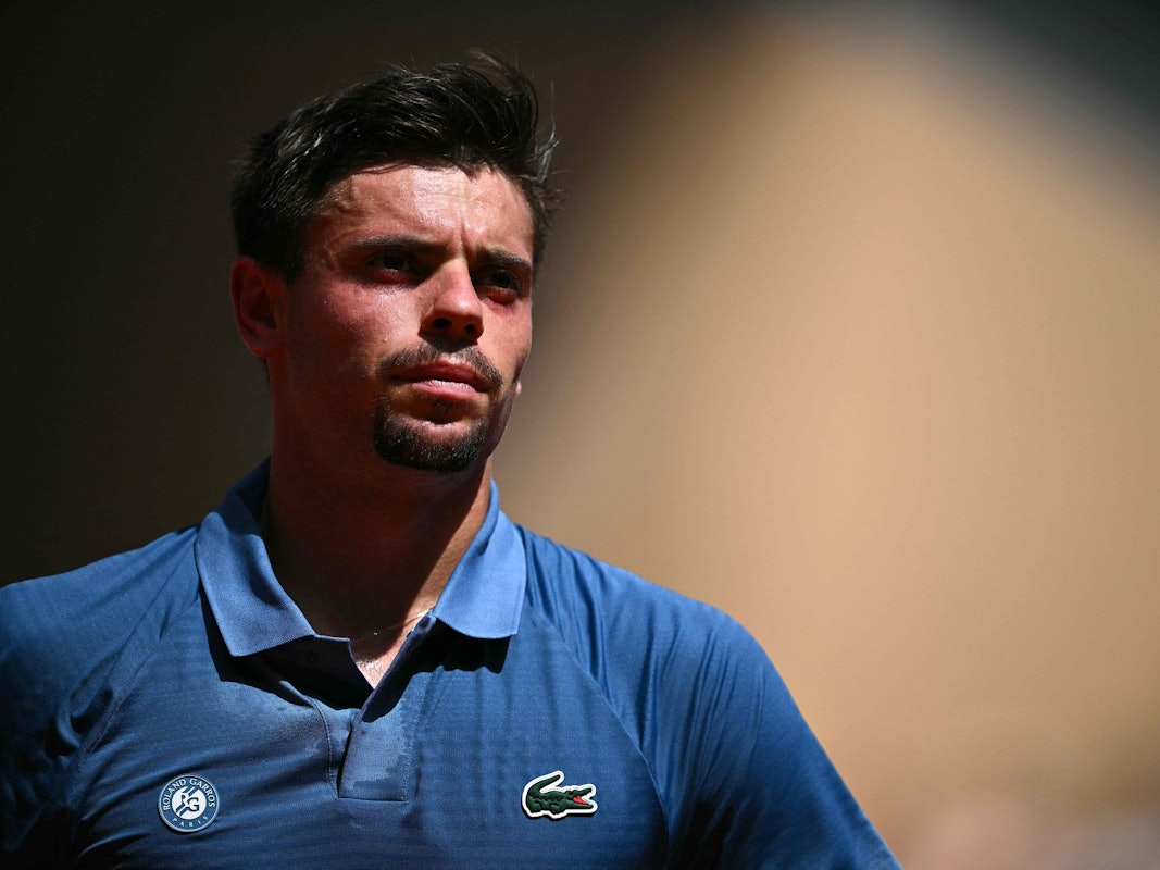 Arthur Géa trägt bei einem Tennis-Match ein blaues Poloshirt.