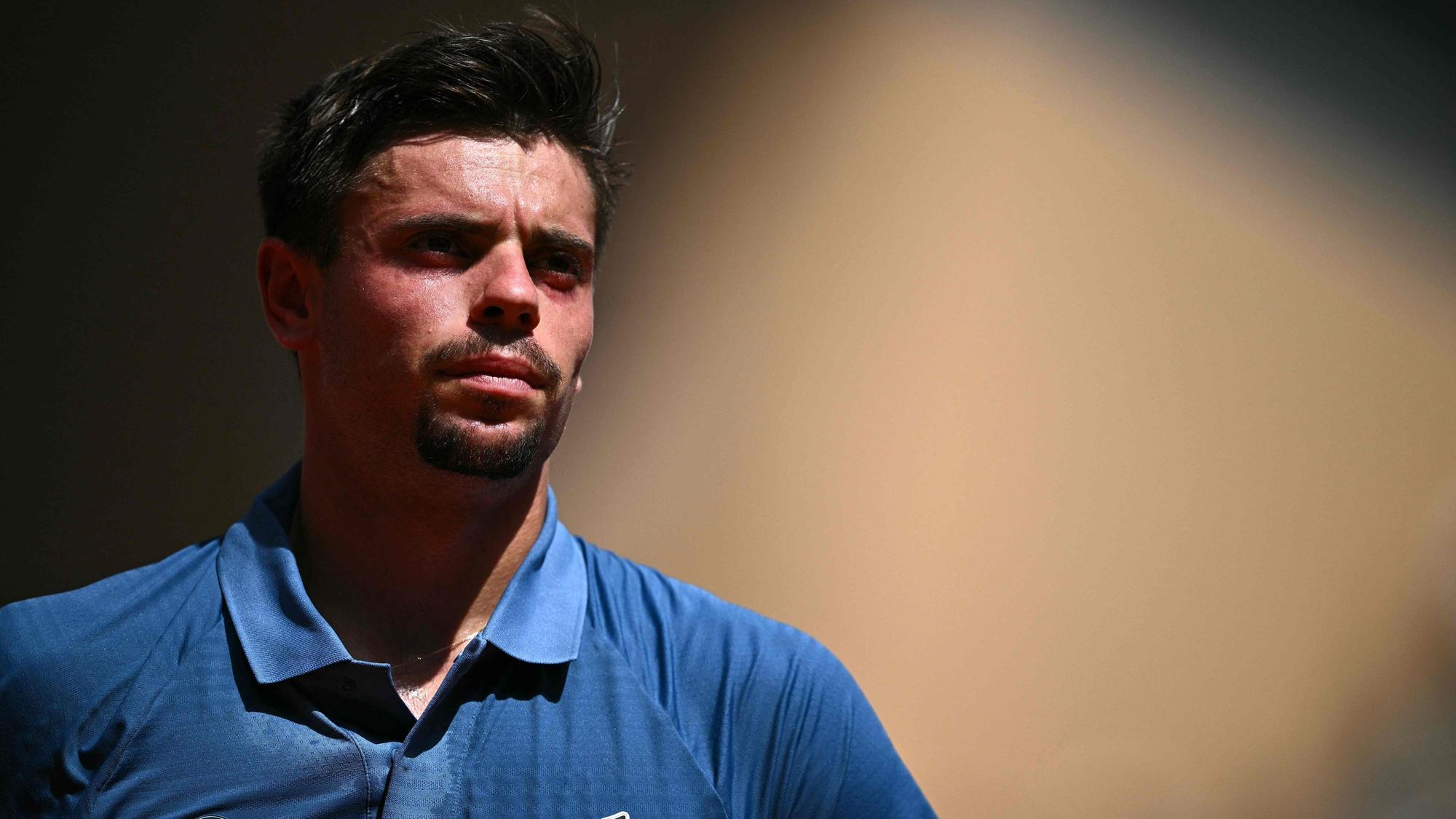 Arthur Géa trägt bei einem Tennis-Match ein blaues Poloshirt.